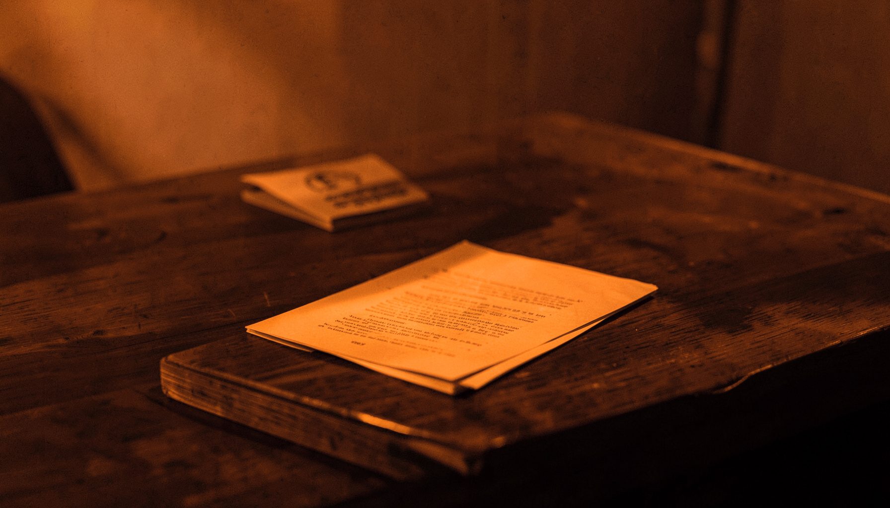 A quiet study with a wooden desk and an open document, warm amber and deep brown tones, calm and orderly atmosphere